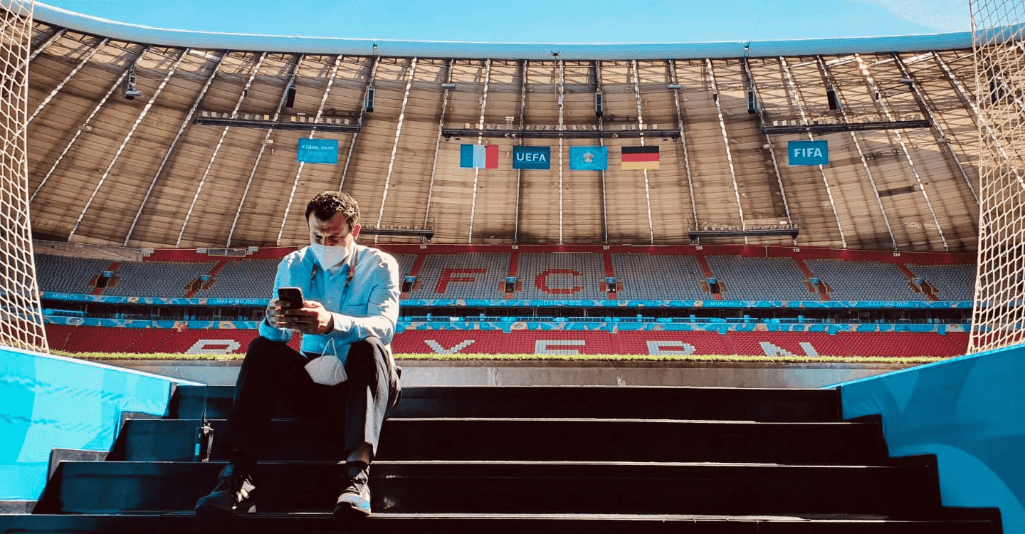 Man sitting on the steps of a football pitch